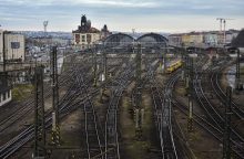 Wide view of a dense railway yard with dozens of tracks, overhead wires, and a distant station building.
